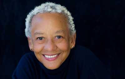Headshot image of woman with black background