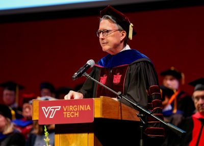 President Sands stands at a podium to speak during spring Commencement.