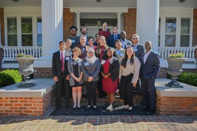 Graduate students attending the graduate student luncheon stand on the steps of The Grove for a picture.
