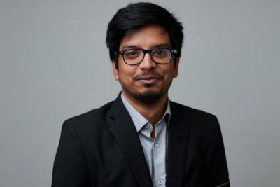 Headshot of Ronnie Mondal in a suit, standing in front of a blank background.