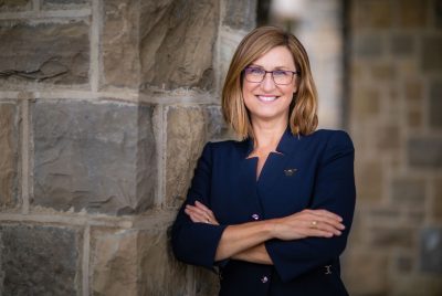 Tracy Vosburgh posing for a photo outside, smiling. 