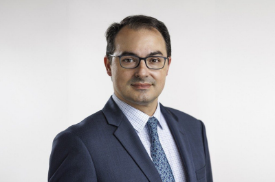 Headshot of Mario Ferruzzi in a suit wearing glasses.