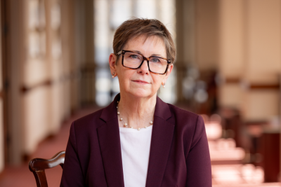 Portrait of Monecia Taylor wearing a blazer and sitting indoors.