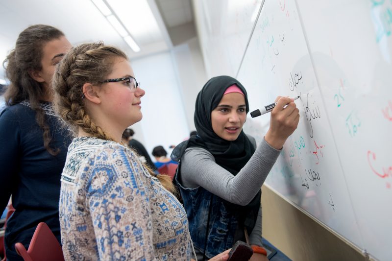 Group of students working around a white board